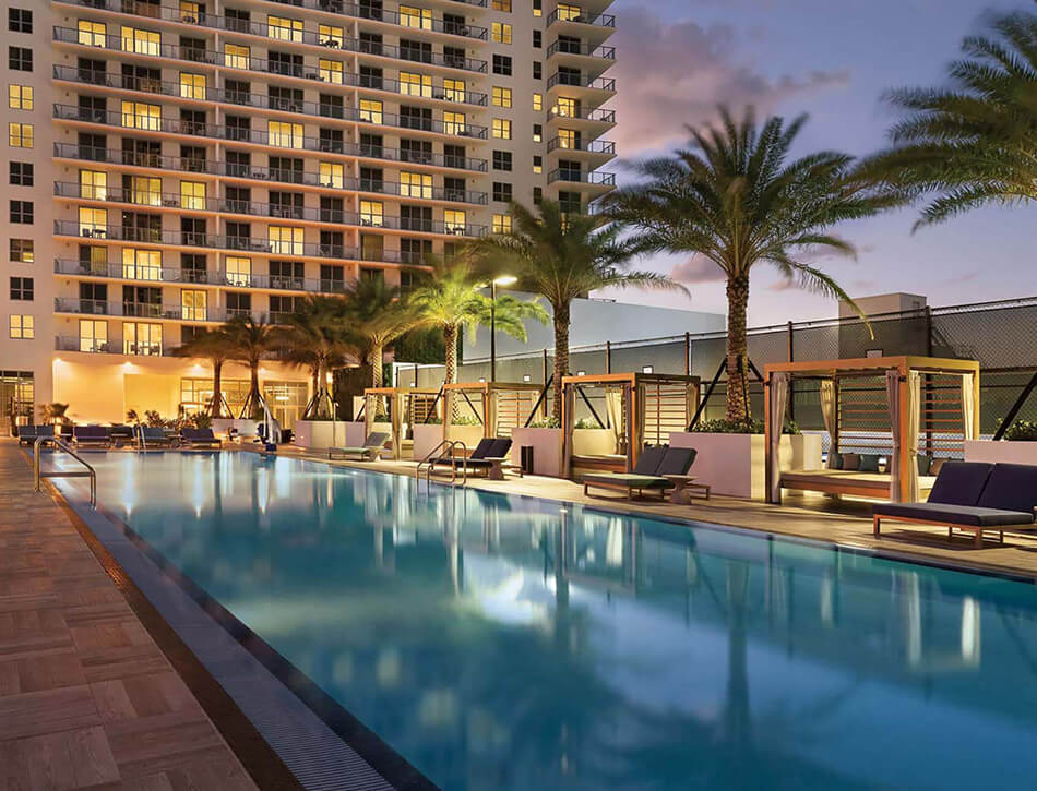 Resort pool at night with palm trees